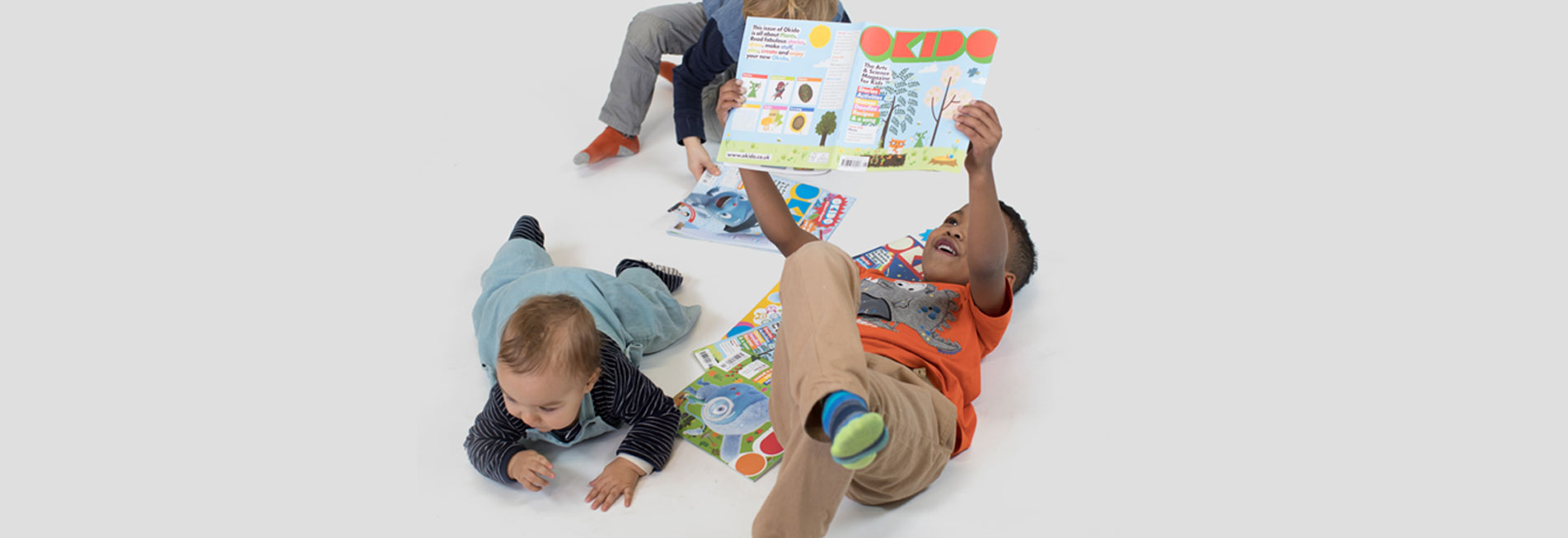 Children playing and reading OKIDO magazine